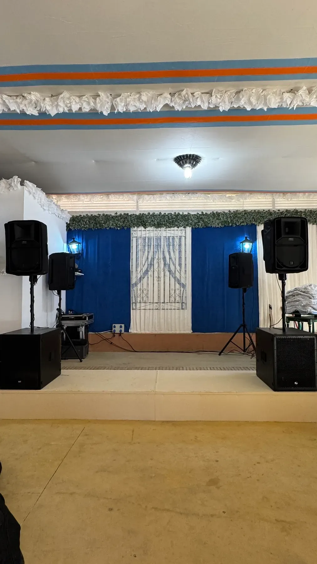 Equipo de sonido con altavoces y subgraves instalado en el escenario de una caseta