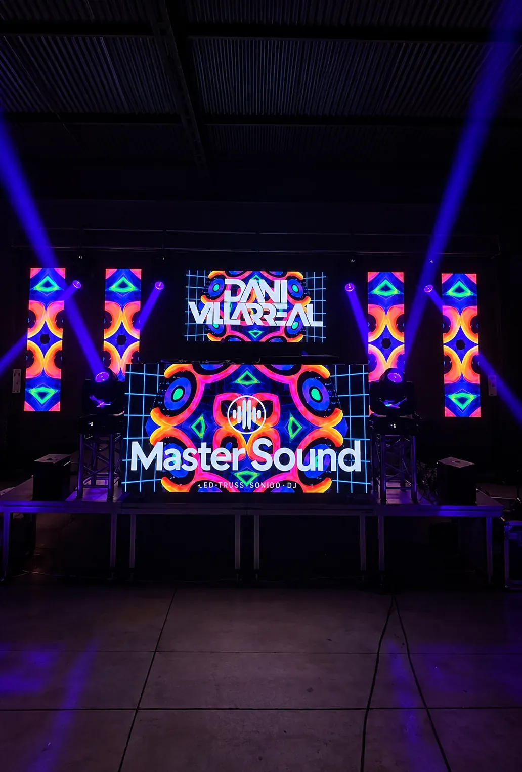 Escenario con pantalla LED del logotipo Master Sound entre haces de luz púrpura